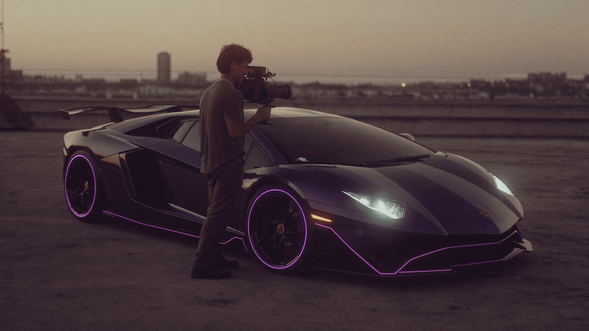 A creator with a gimbal filming a supercar at golden hour